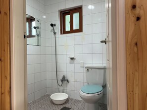 A small, tiled bathroom with a shower, toilet, and sink. - MAUMAEGOHYANG Pension (Cheongdo)