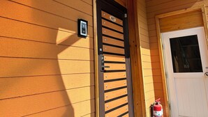 A wooden building with a black gate marked '807' and a white door. - MAUMAEGOHYANG Pension (Cheongdo)