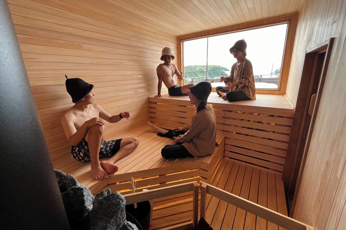 A wooden sauna with benches and a window.