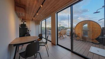 A modern interior with a wooden ceiling, large windows, and a view of the outdoors.