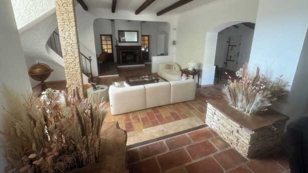 A spacious living area with a fireplace, a stone wall, and a white sofa. - Lovely Mas provençal on the route de Pagnol. Sleeps 10/12. (Marseille)