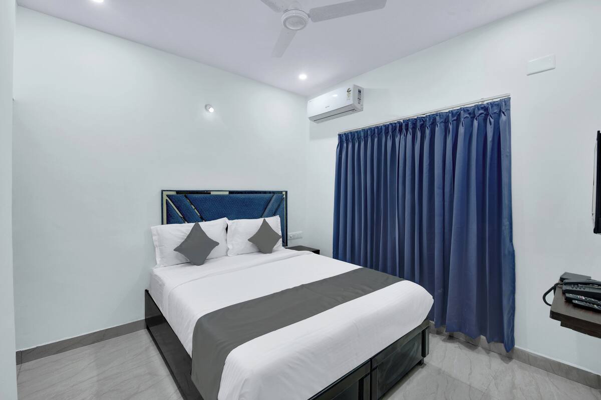 Une chambre d’hôtel moderne équipée d’un lit, de la climatisation et d’un ventilateur de plafond.