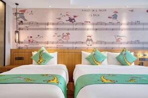 A hotel room with two beds, each with a giraffe-themed bedspread and matching pillows.