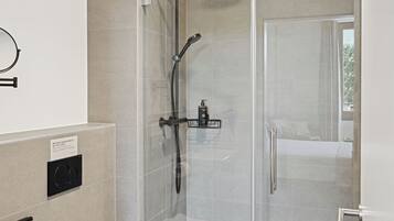 Une salle de bain moderne avec une douche à parois de verre, des toilettes et un lavabo.