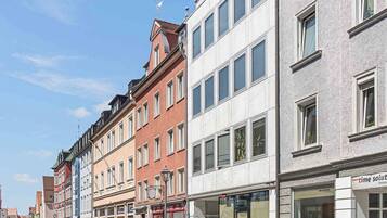 A street with multi-story buildings, including a shop with a sign that reads "time solution".