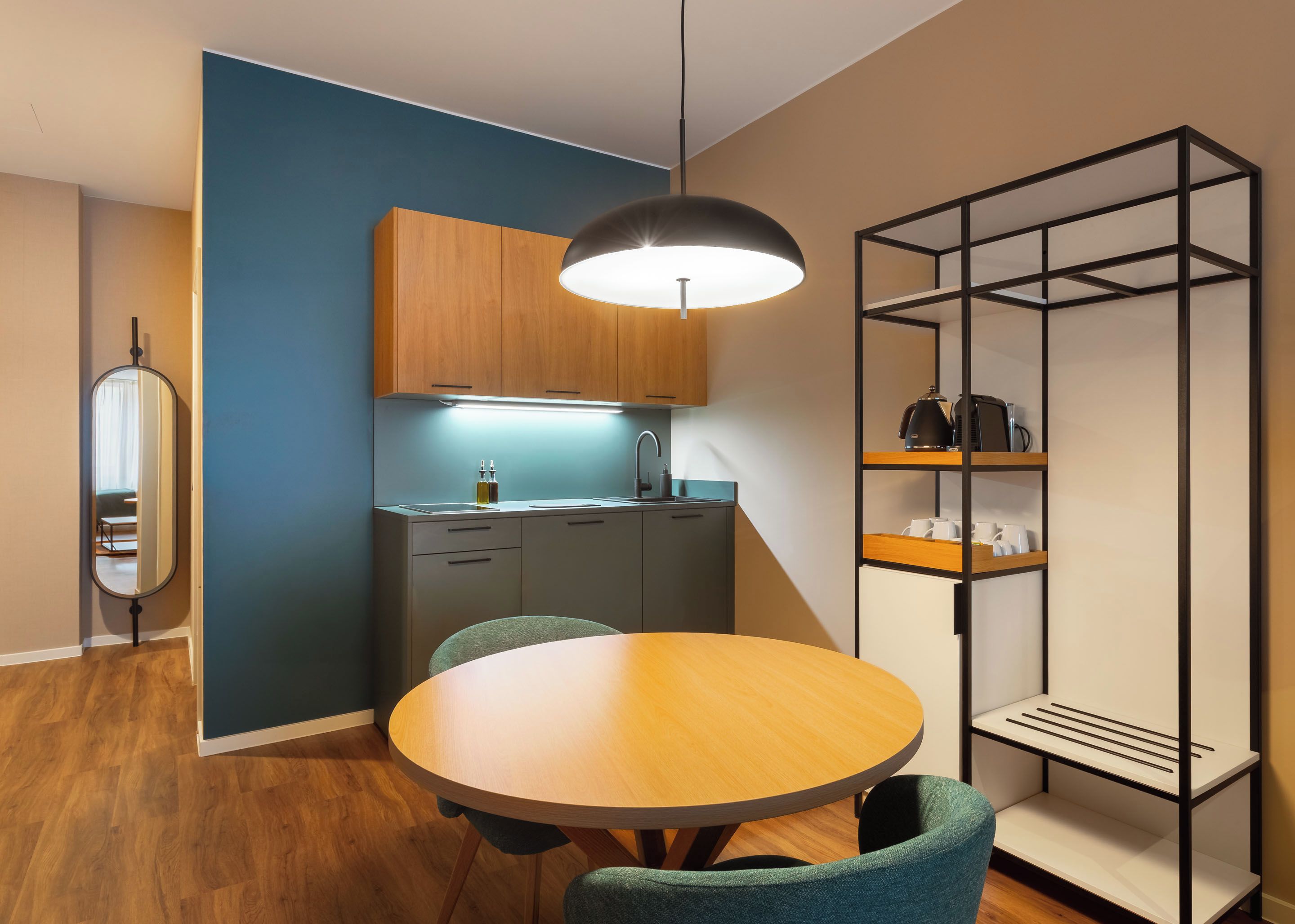 Een compacte keuken met moderne apparatuur, een eettafel met stoelen en een inbouwkast.