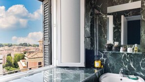 A bathroom with a marble sink, a mirror, and shelves with toiletries. - Elysium Suites Colosseo (Rome)