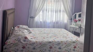 A bedroom with a bed, a dresser, and a mirror.
