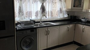 A kitchen with a washing machine, a sink, and cabinets. - 4 Bed Gated House-sleeps 8-private Parking (Harare)