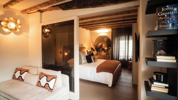 Ein modernes Schlafzimmer mit einem großen Bett, einer Couch und einem Bücherregal.