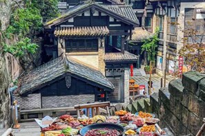 A traditional building with a tiled roof and a courtyard with food offerings.