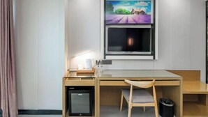 A modern room with a desk, chair, and a flat-screen TV mounted on the wall. - Lavande Hotel (Chongqing Guanyinqiao Pedestrian Street) (Chongqing)
