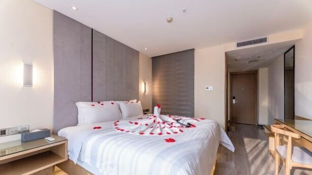 A modern hotel room with a large bed, bedside table, and a mirror. - Lavande Hotel (Chongqing Guanyinqiao Pedestrian Street) (Chongqing)