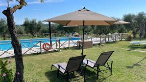 Zona de piscina amb una zona d'estar coberta, un bou salvavides i una piscina.