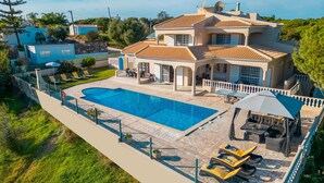A large house with a swimming pool, outdoor seating, and a garden. - Villa Paloma (Albufeira)