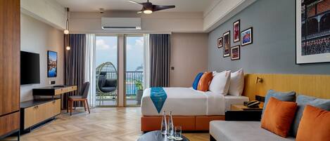Una habitación de hotel moderna con cama, sofá, escritorio y televisor.