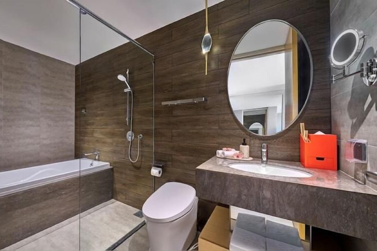 Une salle de bain moderne équipée d’une baignoire, d’une douche, d’un lavabo et de toilettes.