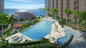 A resort with a large pool, palm trees, and a view of the ocean. - Birkin International Hotel (Malacca City)