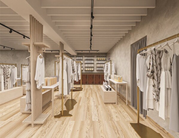 Un espacio comercial moderno con piso de madera, percheros y estanterías que exhiben productos.