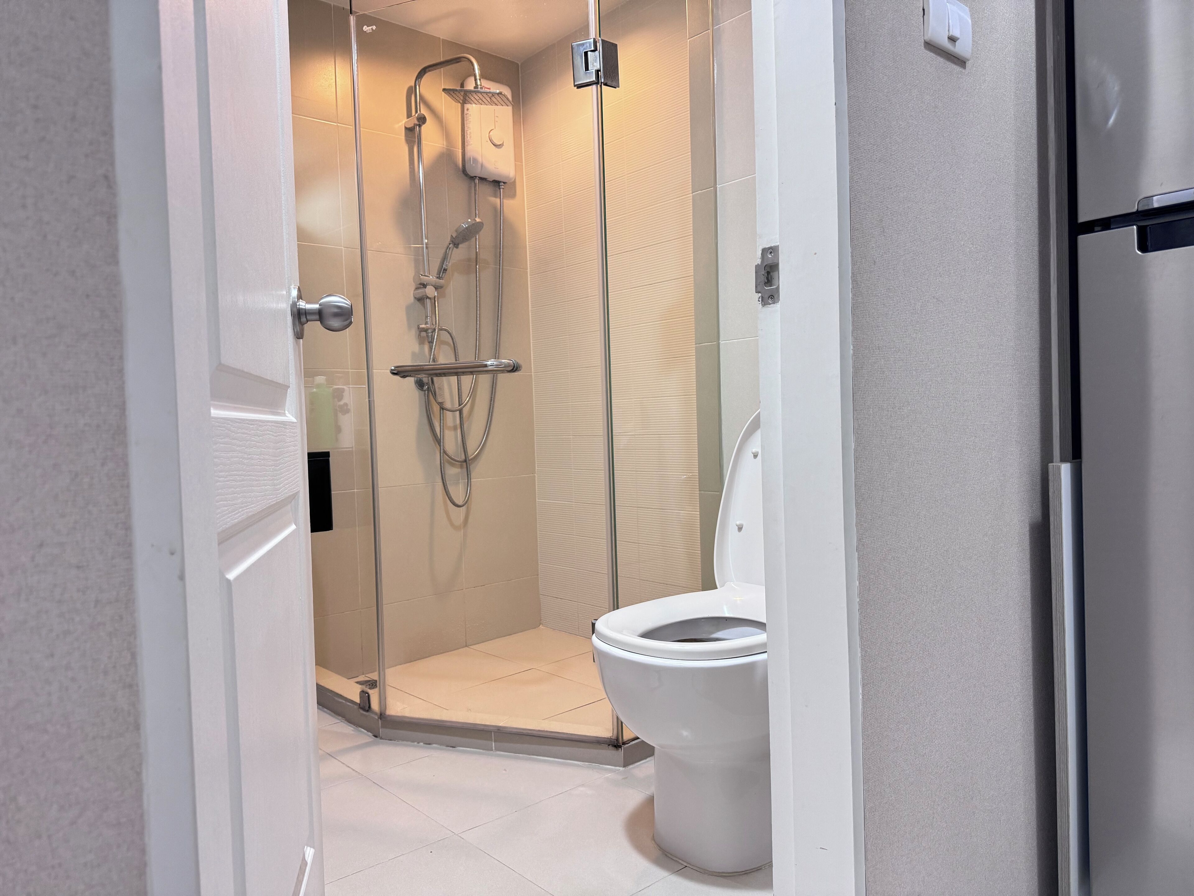 A modern bathroom with a glass-enclosed shower, a toilet, and a white sink.