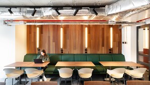 A modern meeting room with a long table, green sofa, and chairs. - Students Studios - Student Accommodation Only (Barceelona)