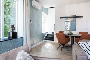 A modern dining area with a table and chairs, a staircase, and a view of greenery outside. - 2 Bedroom Apartment with 4 Beds and a chairbed - Perfect for groups! (Nijmegen)