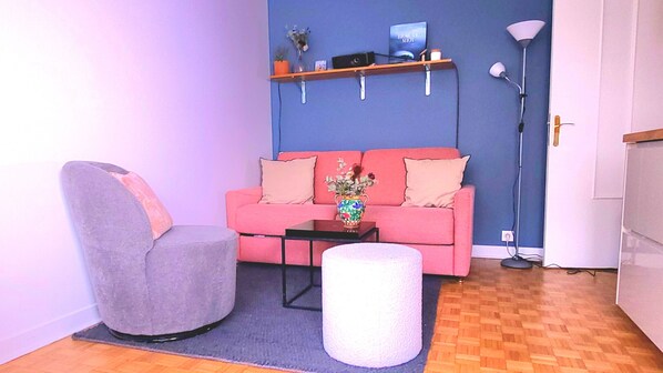 Un salon avec un canapé, un fauteuil, une table basse et une lampe.