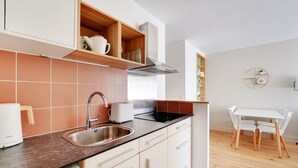 A modern kitchen with a stainless steel sink, white cabinets, and a wooden countertop.