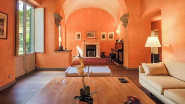A spacious living room with an arched ceiling, a fireplace, and a sofa.