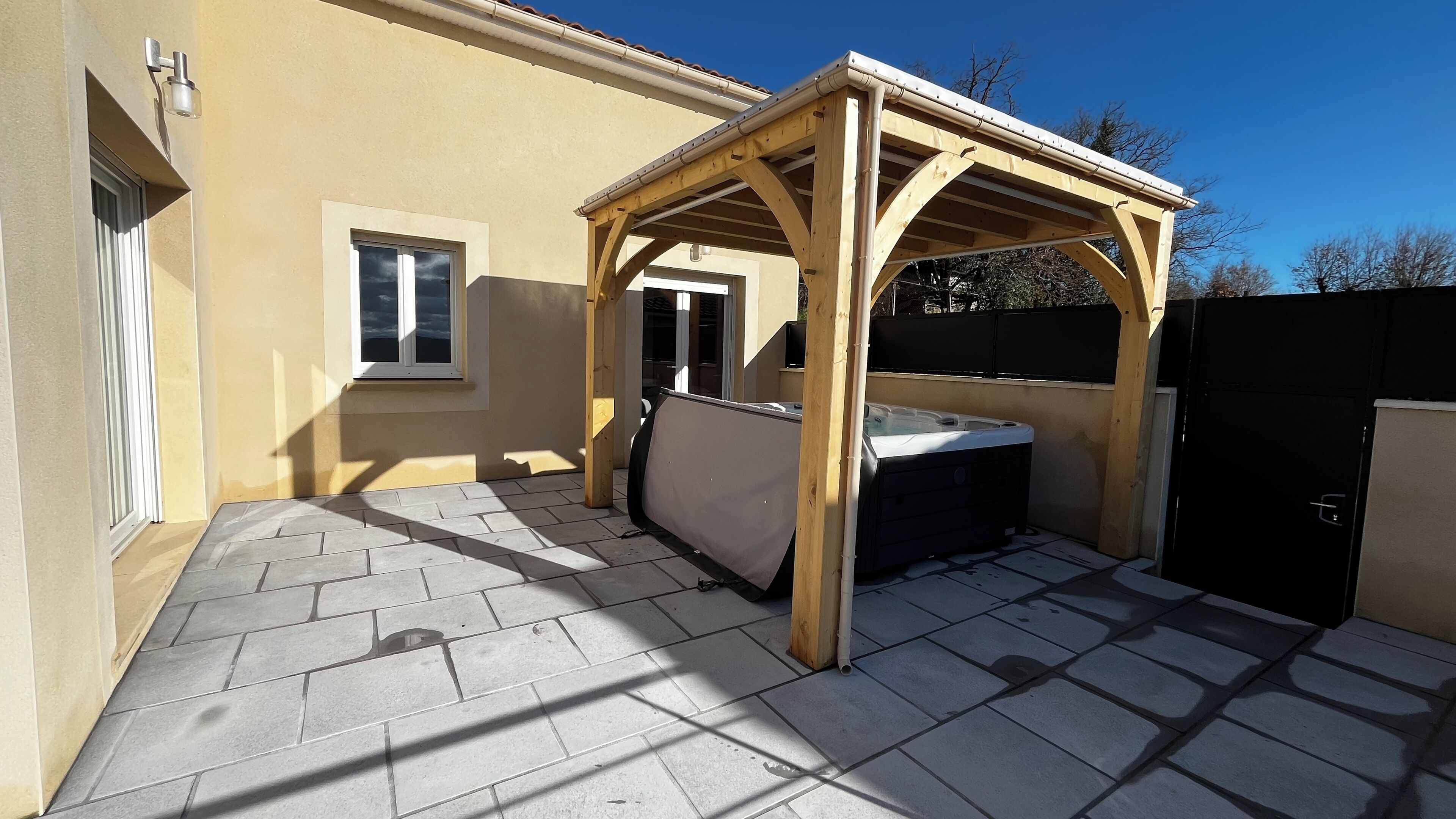 Un porche cubierto con un jacuzzi, una ventana y una puerta.