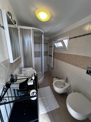 Regadera, secadora de cabello, bidet, toallas