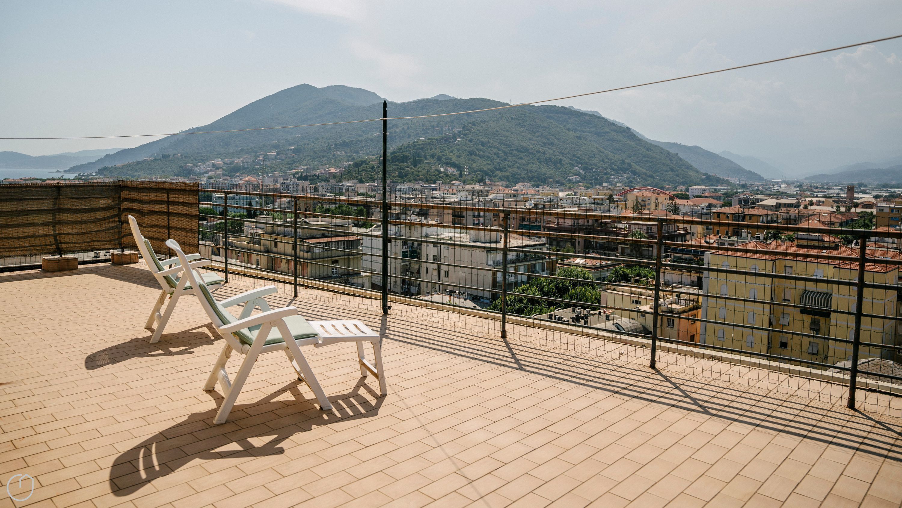 Une terrasse sur le toit offrant une vue sur le paysage urbain et les montagnes.