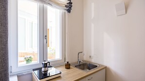 A modern kitchen with a window, a sink, and a stove. - Direlo Guest House (Naples)