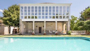 Un bâtiment à deux étages avec une piscine devant.