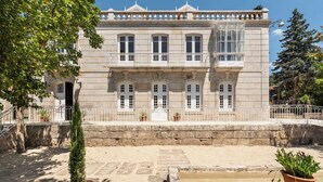Un bâtiment historique à la façade symétrique, doté de nombreuses fenêtres et d’une entrée centrale.