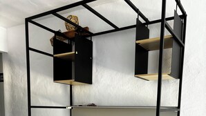Eine Küchenzeile im Schwarz-Holz-Design mit Spüle, Schränken und Ablagefläche.