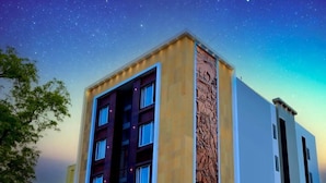 Ein mehrstöckiges Hotel mit einem auffälligen Schild, auf dem "VITHA GRAND" steht.