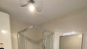 Une salle de bain moderne avec une douche à parois de verre, des toilettes, un lavabo avec un miroir et un tapis vert.