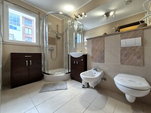 Standaard suite | Badkamer | Een douche, een haardroger, handdoeken, toiletpapier