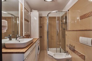 Standaard suite | Badkamer | Een douche, een haardroger, handdoeken, toiletpapier