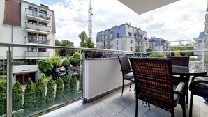 A balcony with outdoor furniture, a view of neighboring buildings, and a clear sky. - Stella Baltic by Baltic Home (Swinoujscie)
