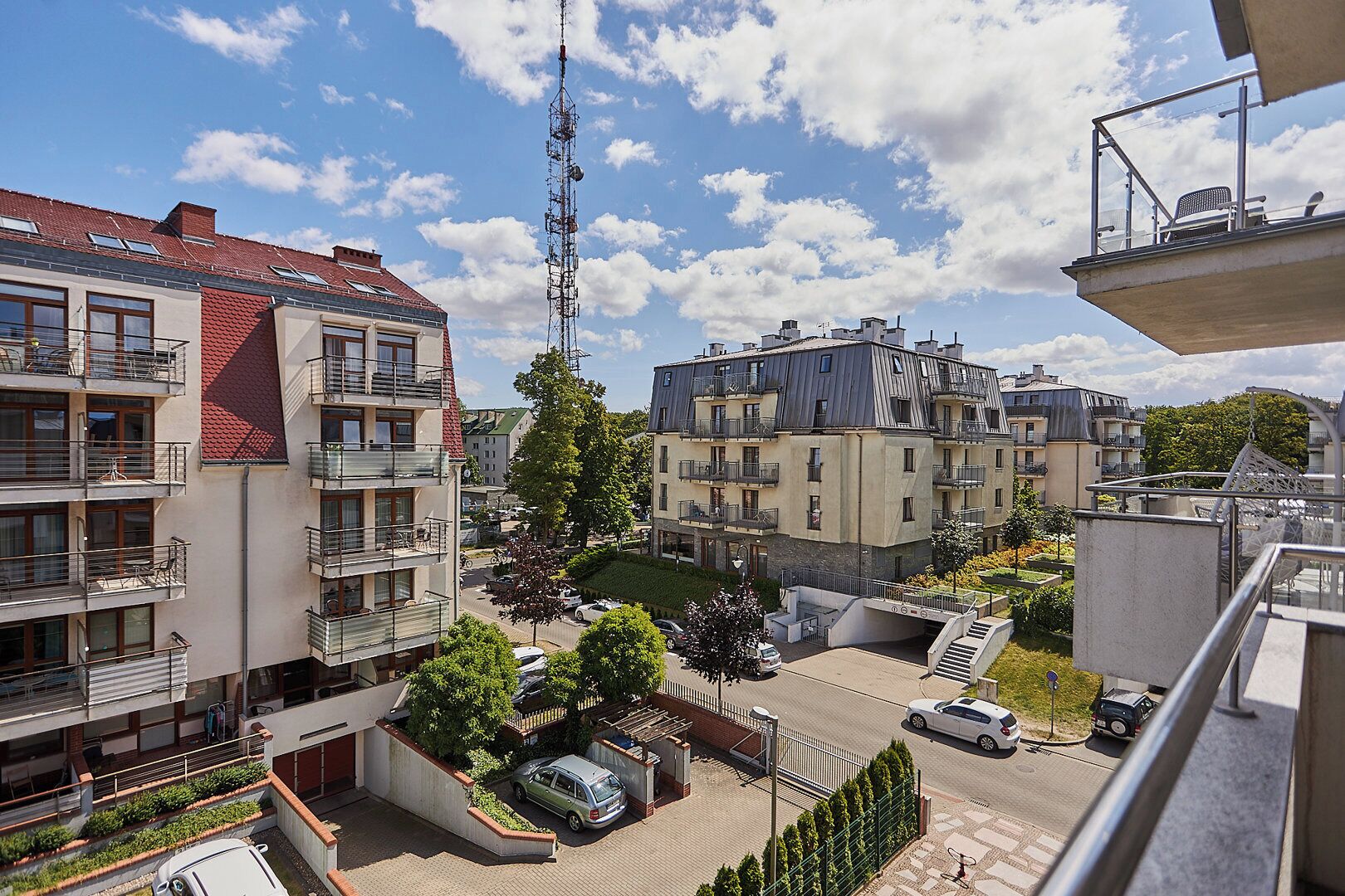 A residential area with multi-story buildings, balconies, and a clear sky.