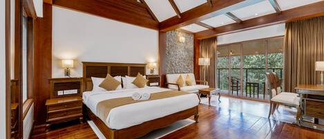A spacious bedroom with a large bed, wooden beams, stone accent wall, and a view of the outdoors.