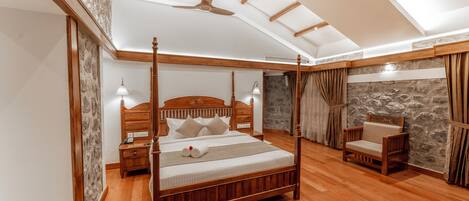 A four-poster bed with a wooden headboard, a nightstand, a bedside table, and a chair.