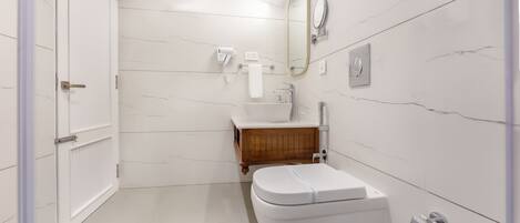 A modern bathroom with a toilet, sink, and vanity.