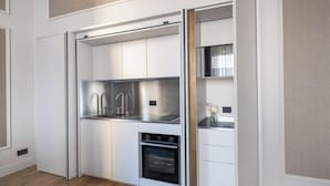 Una cocina compacta con electrodomésticos integrados, horno empotrado y una pequeña encimera.