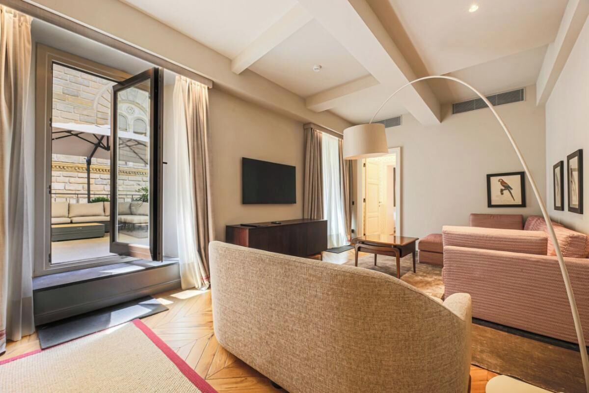 A modern living room with a sofa, a TV, and a dining area.
