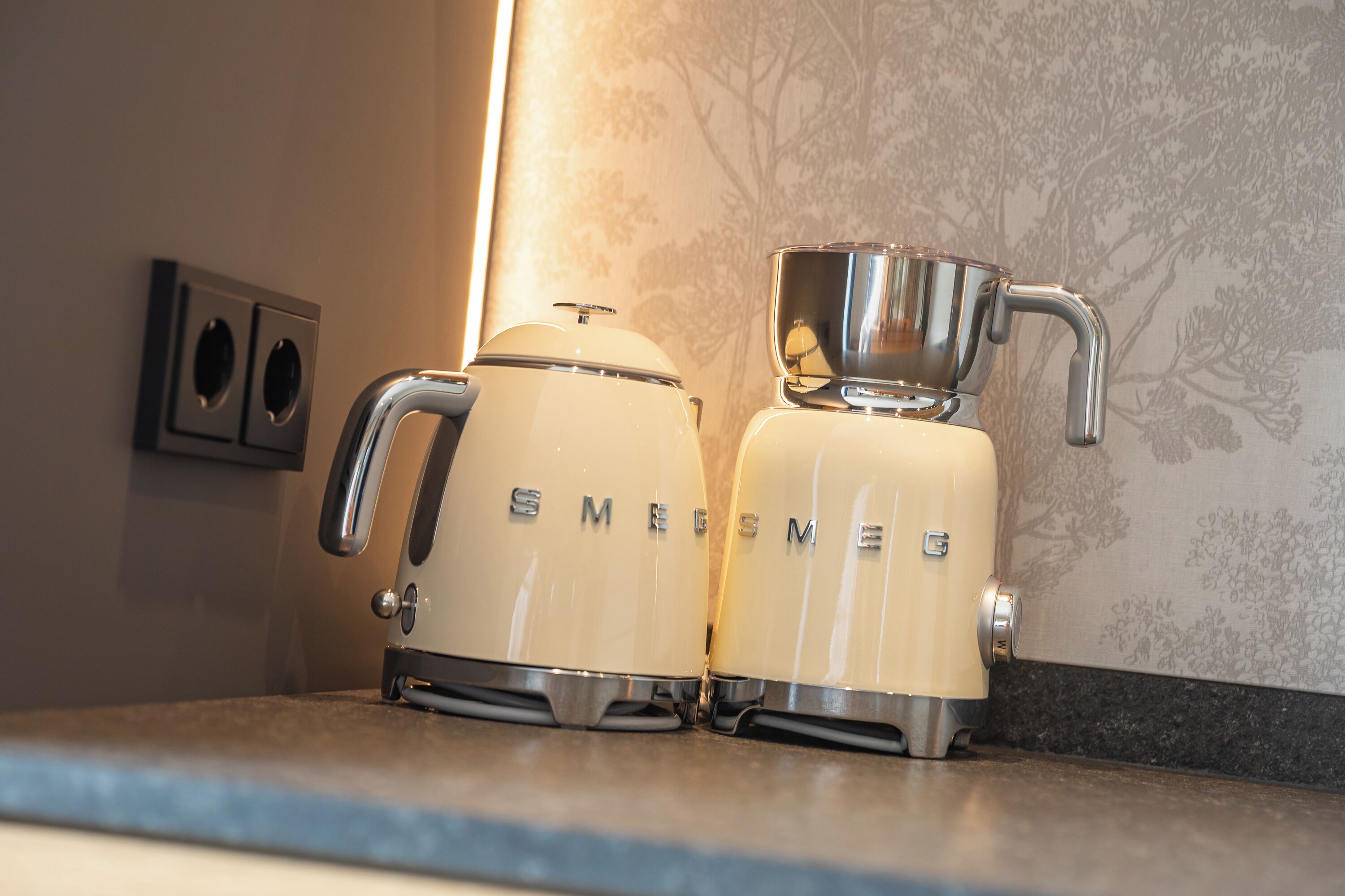 Una cocina con cafetera y hervidor en la encimera.