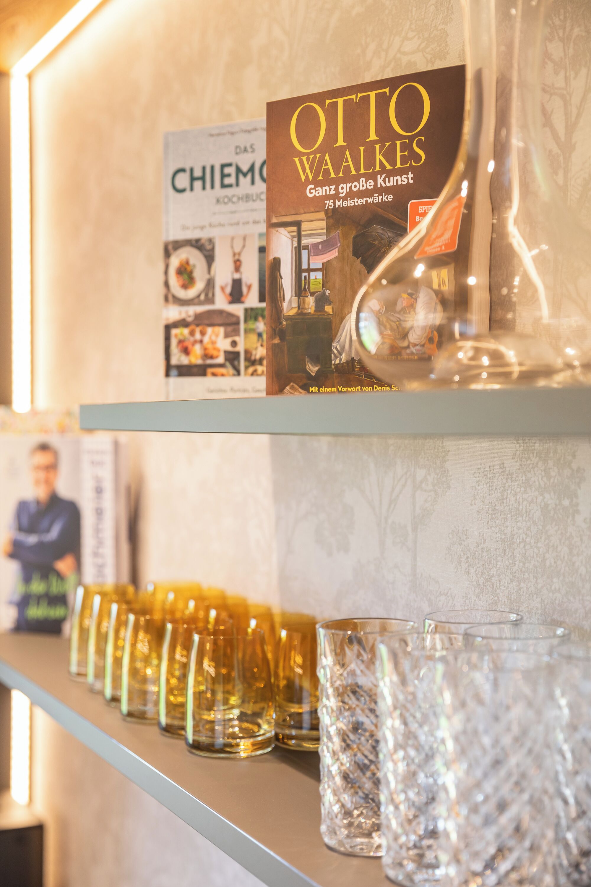 A shelf with a book titled 'OTTO WAALKES' and several glassware items.