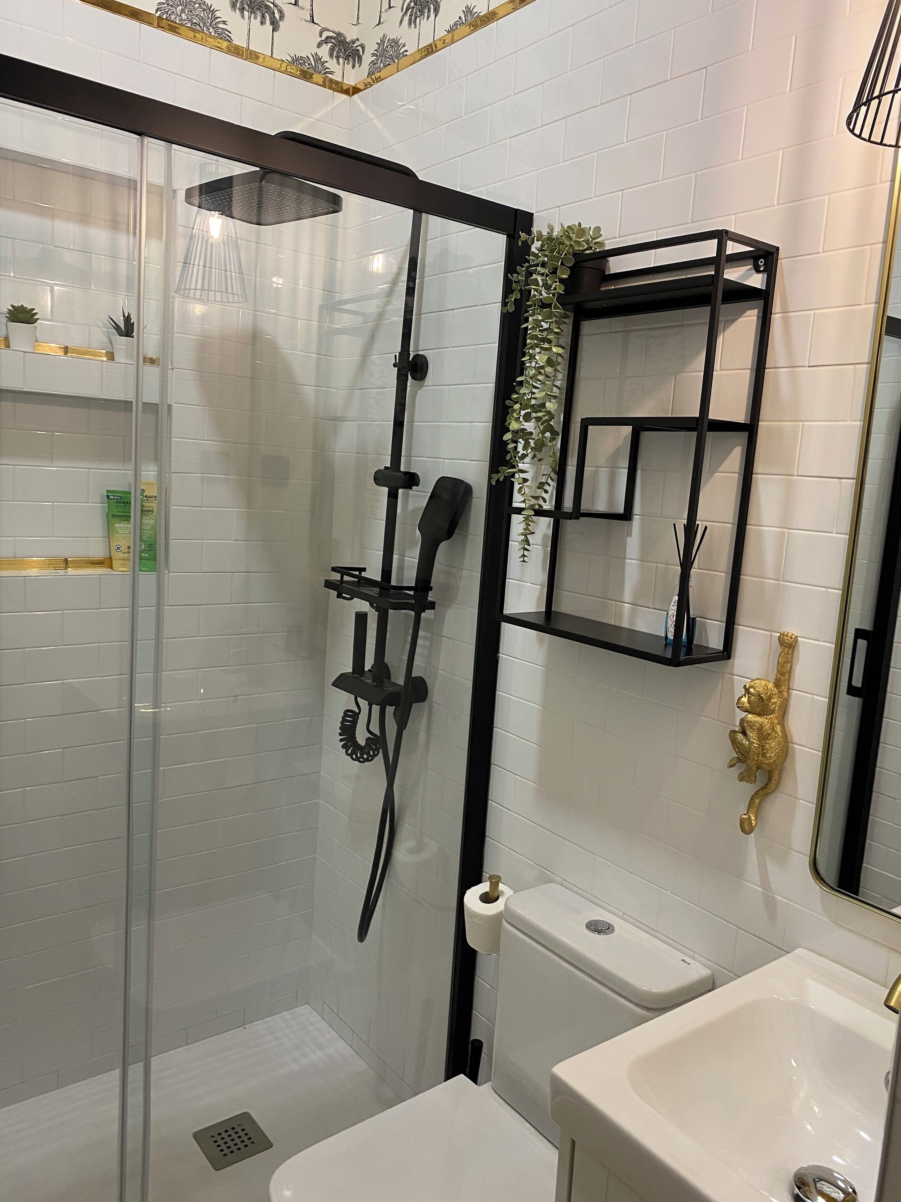A modern bathroom with a glass-enclosed shower, a toilet, and a sink.